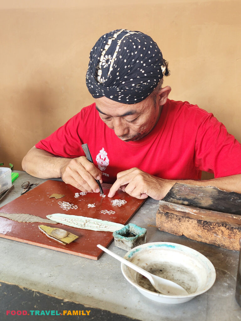 An artist working on a bracelet